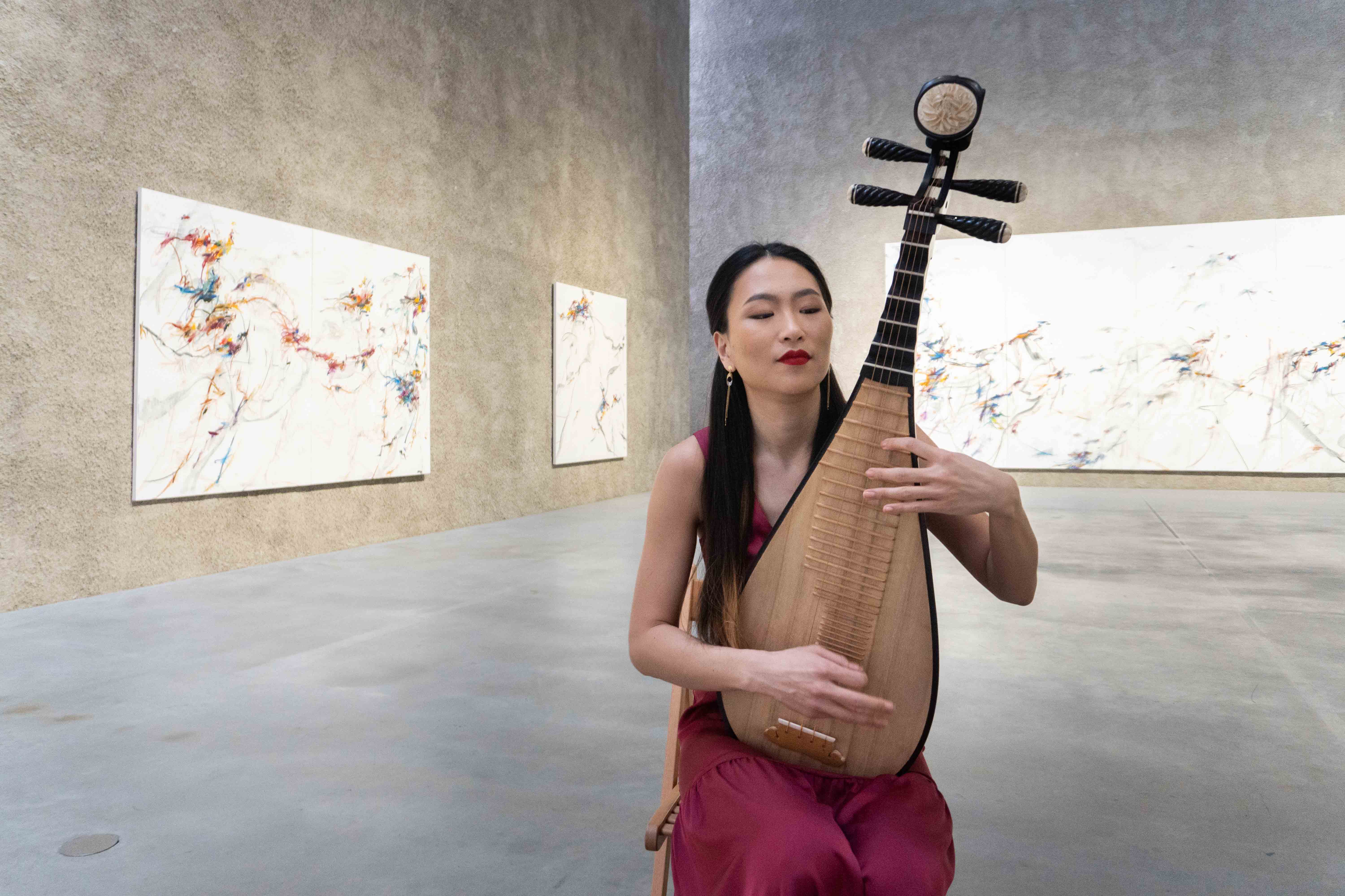 Lucy Zhao performing the pipa in an art gallery during a live performance 