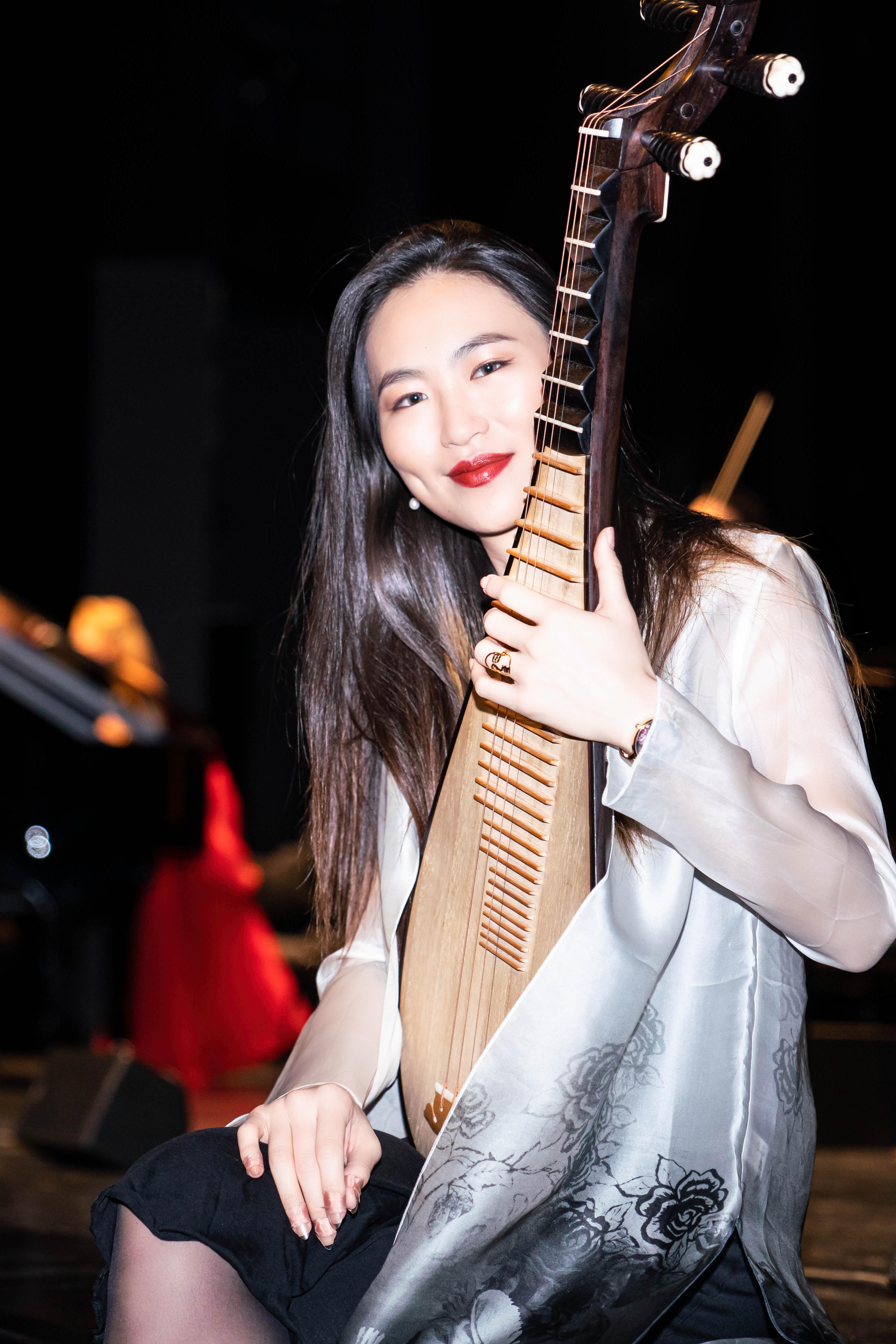Portrait of pipa soloist Lucy Zhao holding the pipa and smiling 