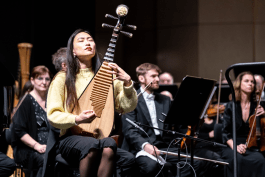 Lucy Zhao performing a pipa solo with orchestra during a concert 