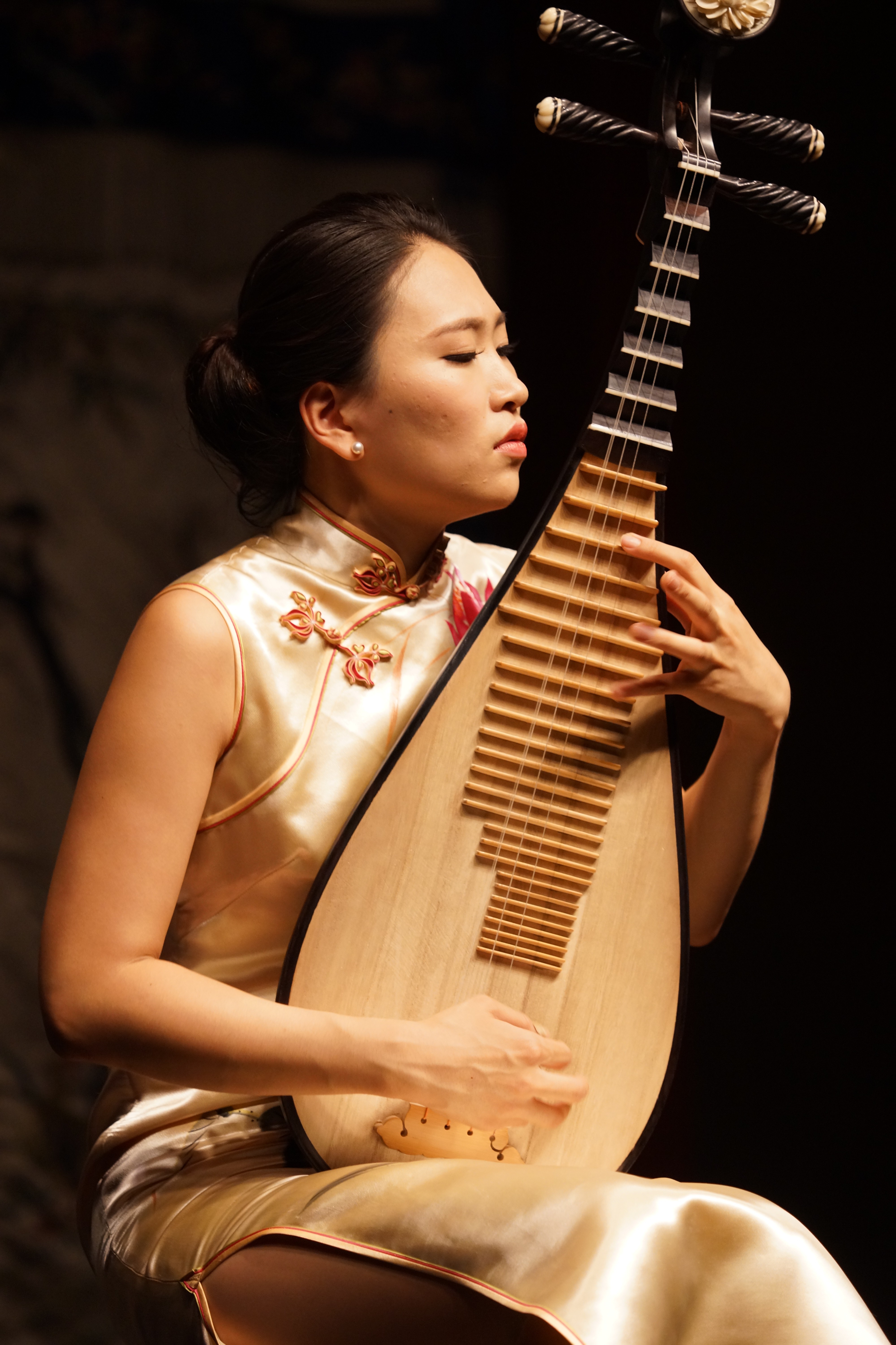 Lucy Zhao playing the pipa with focus on the traditional Chinese instrument 
